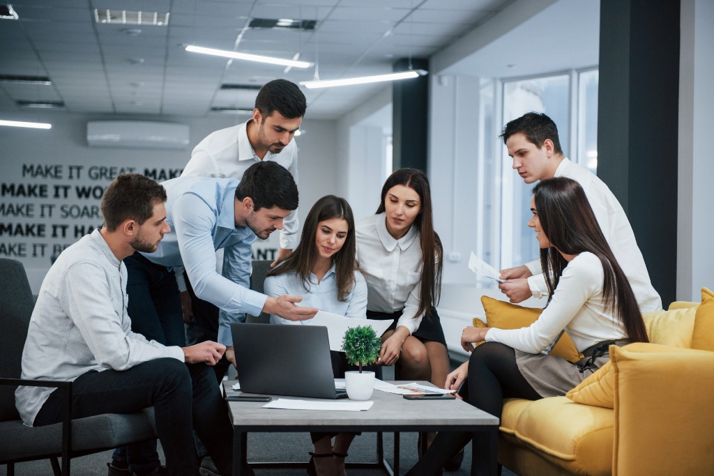 Professionals collaborating around a laptop in an office